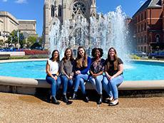 Group of students posed outside near a fountain